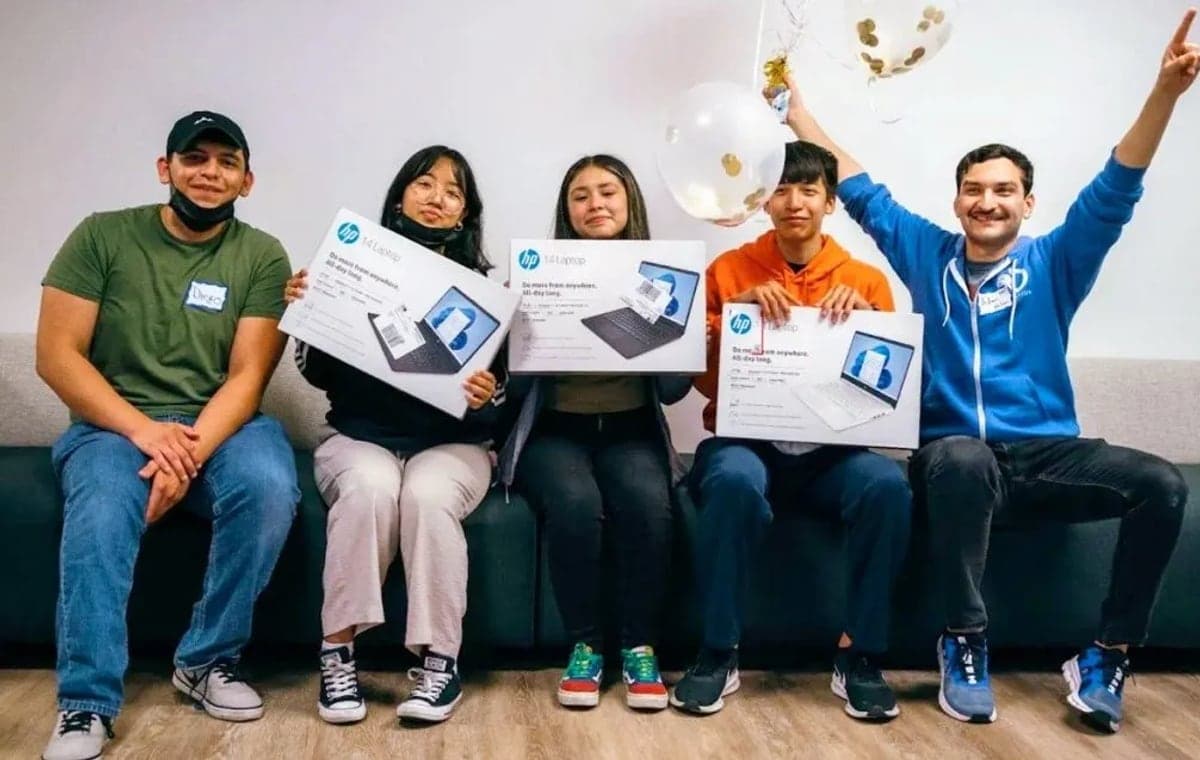 Code Nation students holding new laptops received through the programme