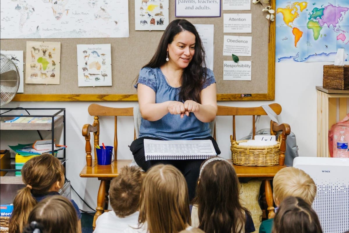A teacher leading a phonemic awareness lesson with a class of young students